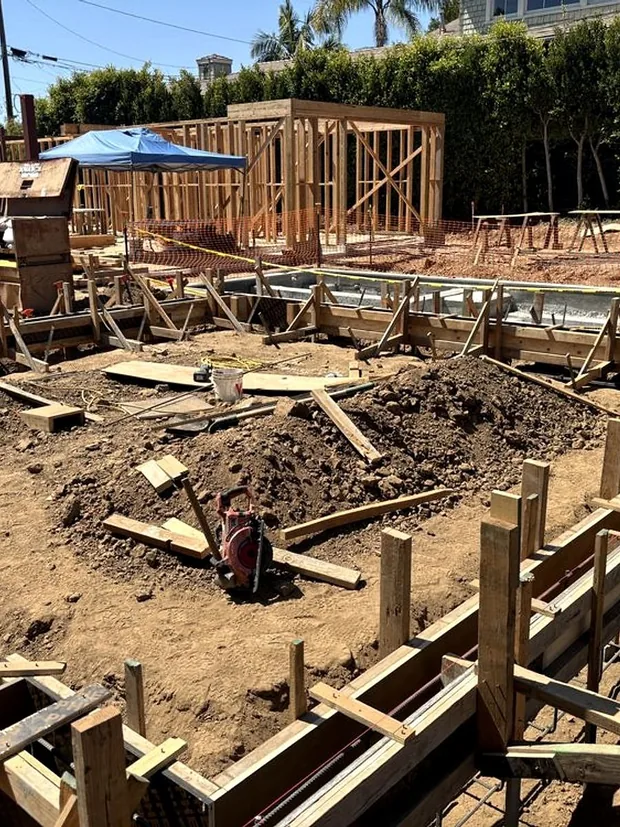 Formed and steeled footing trenches dug around a framed structure