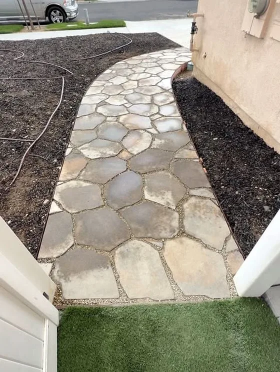 A curving front walkway stamped and coloured to look like irregular flagstone