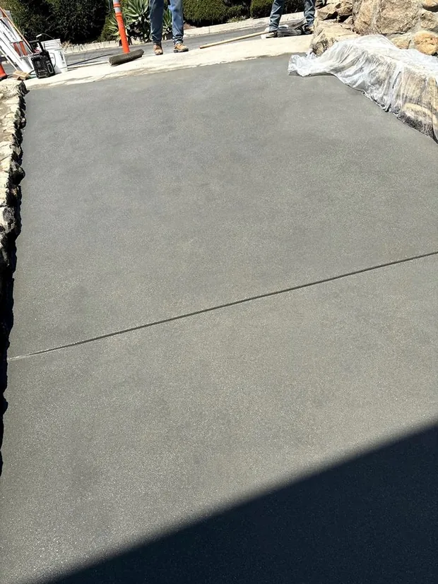 A smooth trowelled concrete surface with a single tooled control joint running across it